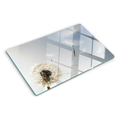 Snijplanken glas Paardenbloemen op de achtergrond van het raam.