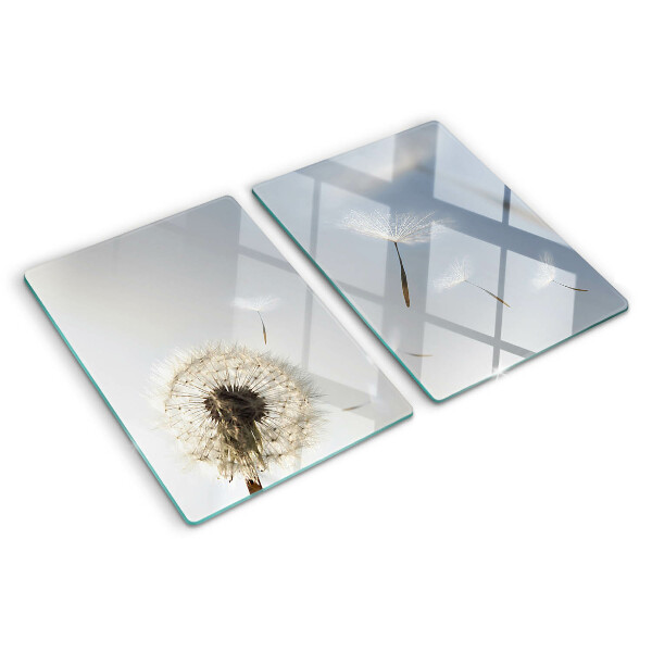 Snijplanken glas Paardenbloemen op de achtergrond van het raam.