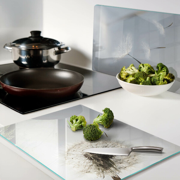 Snijplanken glas Paardenbloemen op de achtergrond van het raam.