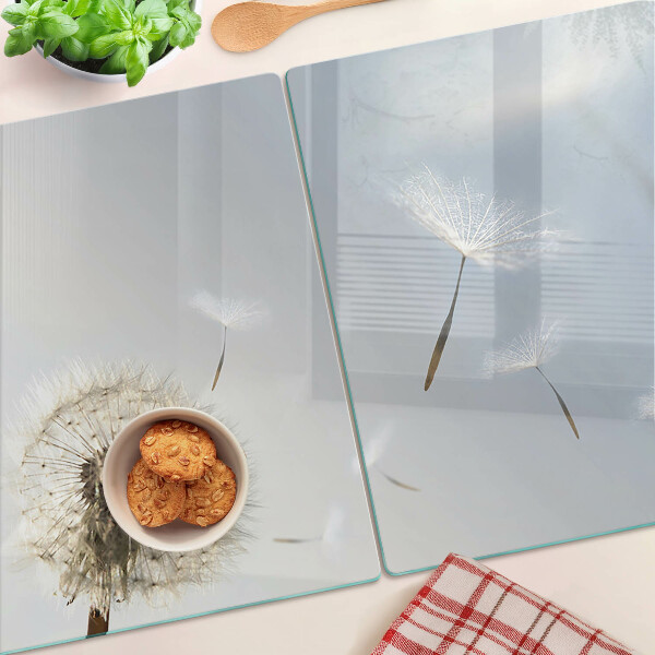 Snijplanken glas Paardenbloemen op de achtergrond van het raam.