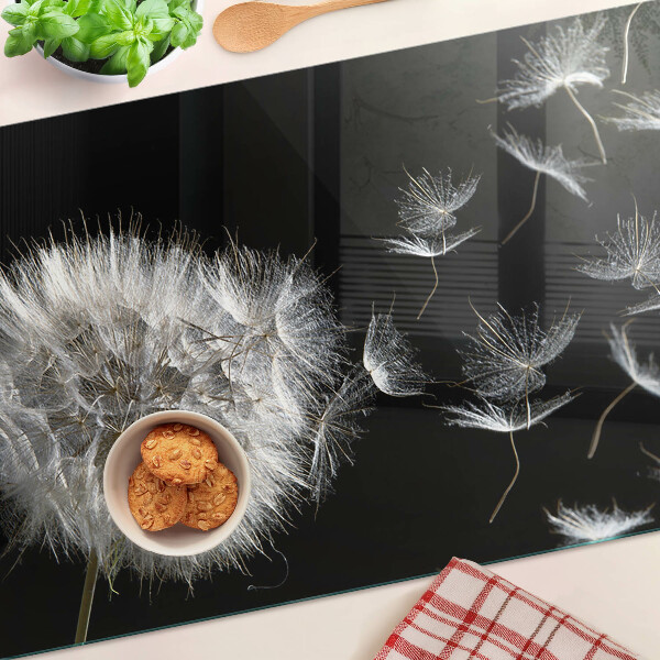 Glazen snijplanken Paardenbloemen op een zwarte achtergrond