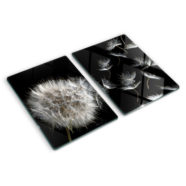 Glazen snijplanken Paardenbloemen op een zwarte achtergrond