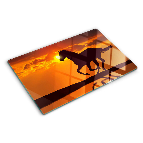 Snijplanken glas Een paard tegen de achtergrond van de ondergaande zon.