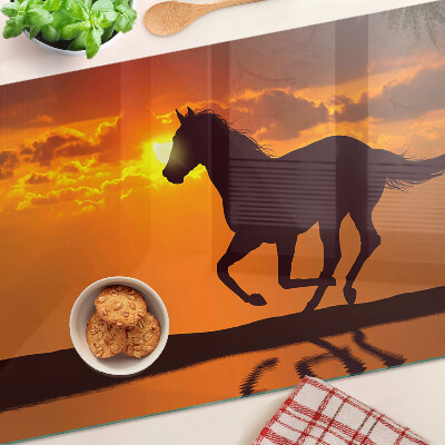 Snijplanken glas Een paard tegen de achtergrond van de ondergaande zon.