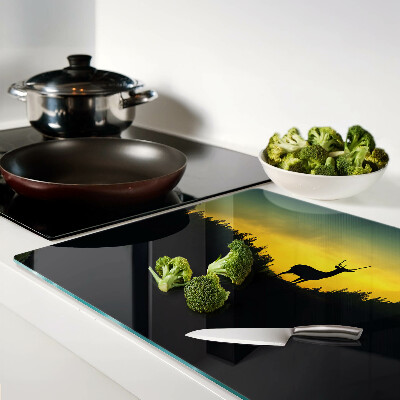 Snijplanken glas Herten tegen de achtergrond van de ondergaande zon.