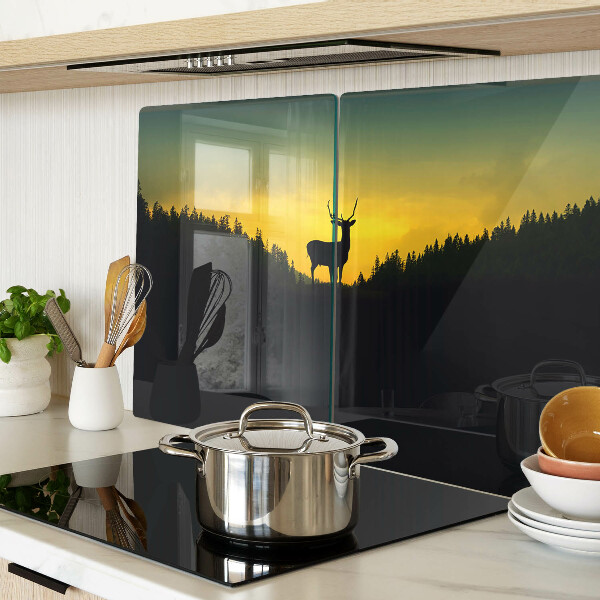 Snijplanken glas Herten tegen de achtergrond van de ondergaande zon.