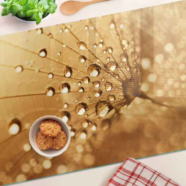 Snijplanken van glas Waterdruppels op een paardenbloem