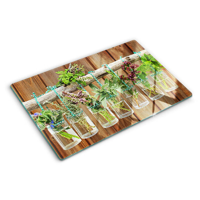 Glazen snijplanken Kruiden in potjes op een houten achtergrond.