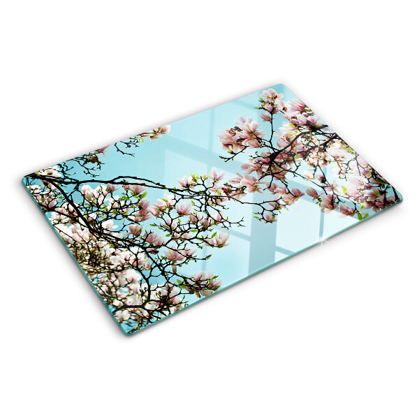 Snijplanken van glas Magnoliabloemen op een blauwe achtergrond