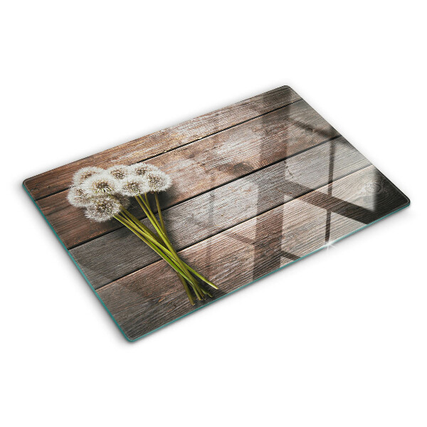 Glazen snijplanken Paardenbloemen op een houten achtergrond