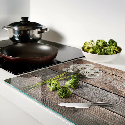 Glazen snijplanken Paardenbloemen op een houten achtergrond