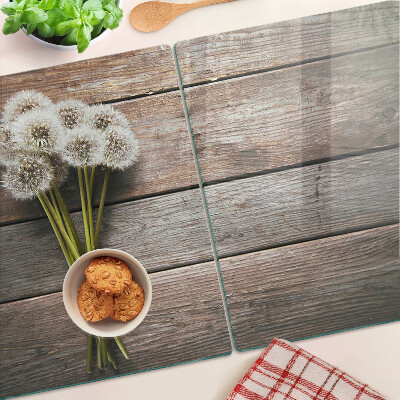 Glazen snijplanken Paardenbloemen op een houten achtergrond