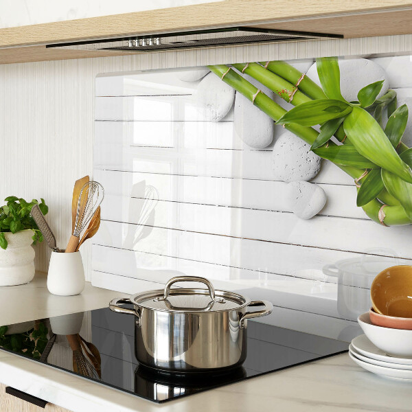 Szklana deska do krojenia Bamboo i kamienie na tle drewna