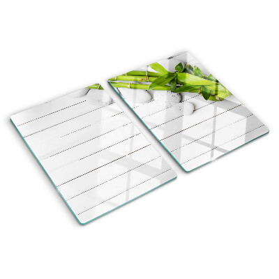 Szklana deska do krojenia Bamboo i kamienie na tle drewna