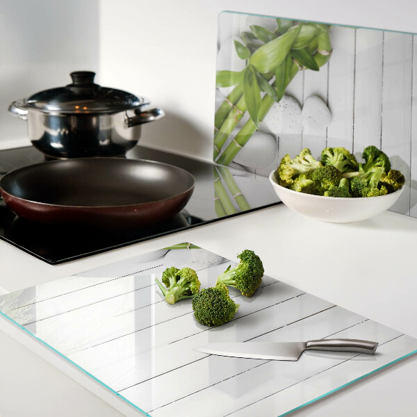 Szklana deska do krojenia Bamboo i kamienie na tle drewna