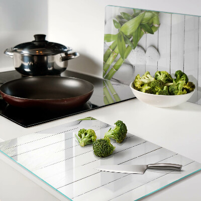 Szklana deska do krojenia Bamboo i kamienie na tle drewna