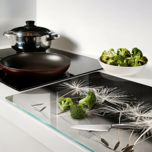 Snijplanken van glas Pluizige paardenbloemen op een monochrome achtergrond.