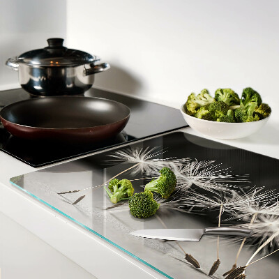 Snijplanken van glas Pluizige paardenbloemen op een monochrome achtergrond.