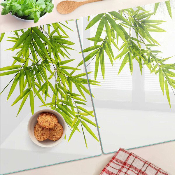 Glazen snijplanken Bamboe bladeren tegen de achtergrond van het raam.