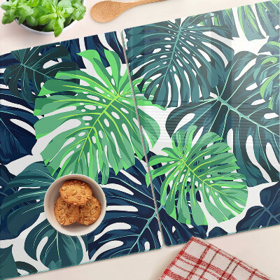 Glazen snijplanken Monstera-bladeren op een tropische achtergrond