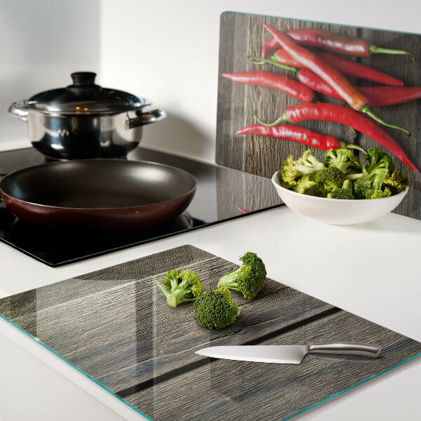 Glazen snijplanken Chilipepers op een houten achtergrond