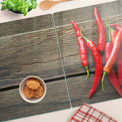 Glazen snijplanken Chilipepers op een houten achtergrond