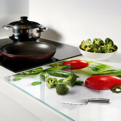 Szklana deska do krojenia Warzywa na tle białego blatu