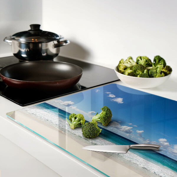 Snijplanken glas Een strand met turquoise water en wolken.