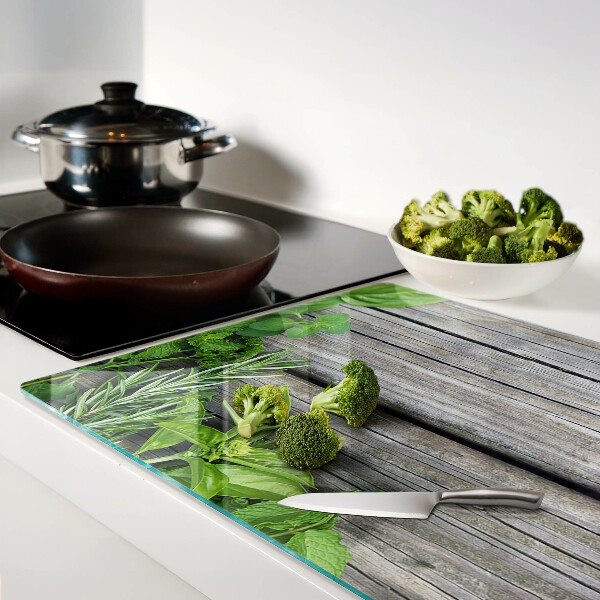 Snijplanken van glas Groene kruiden op een houten achtergrond