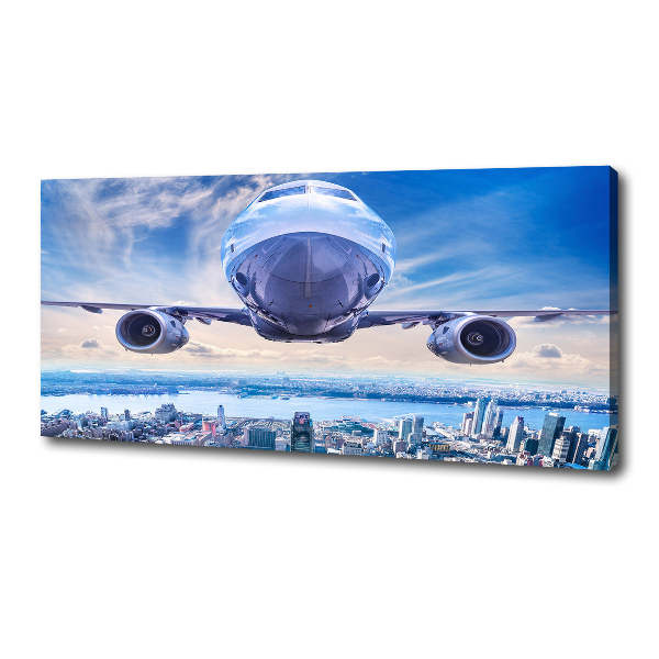 Schilderij op canvas Een vliegtuig boven de stad