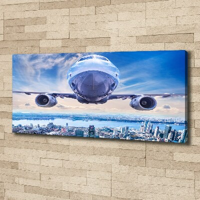 Schilderij op canvas Een vliegtuig boven de stad