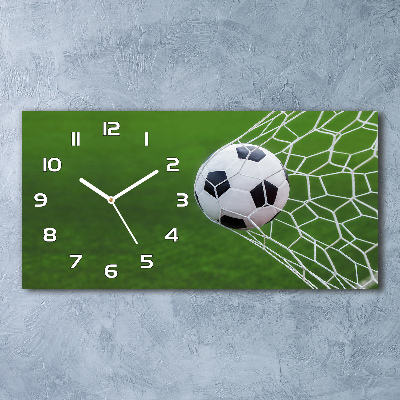 Langwerpige wandklok van glas De bal ligt in het doel.