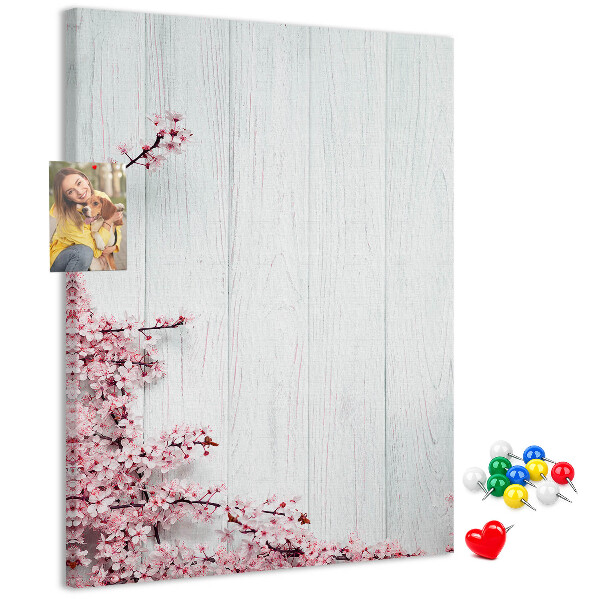 Prikbord van kurk met bloemtakken op een lichte achtergrond