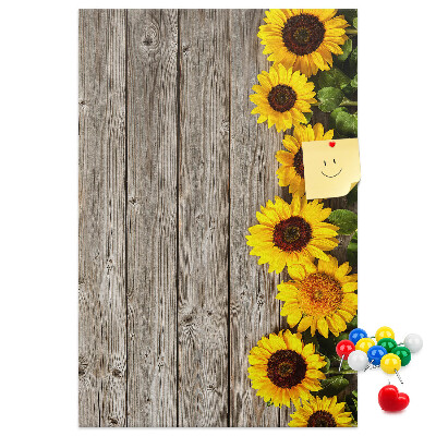 Memobord van kurk met zonnebloemen op een houten achtergrond
