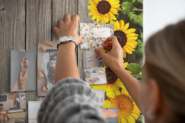 Memobord van kurk met zonnebloemen op een houten achtergrond