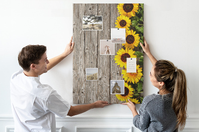 Memobord van kurk met zonnebloemen op een houten achtergrond
