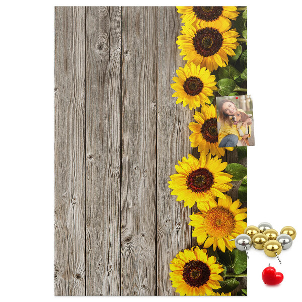 Memobord van kurk met zonnebloemen op een houten achtergrond