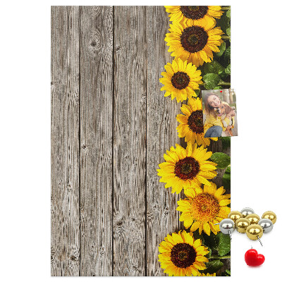 Memobord van kurk met zonnebloemen op een houten achtergrond