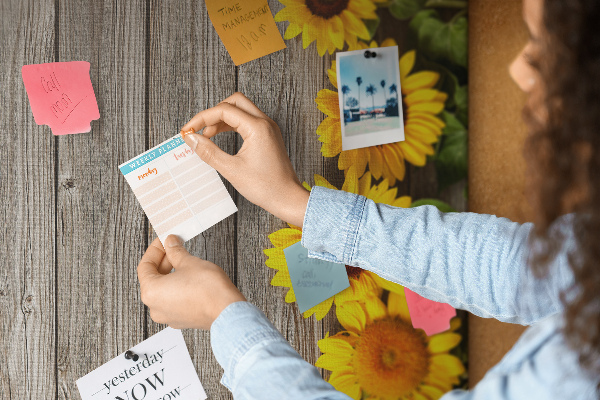 Memobord van kurk met zonnebloemen op een houten achtergrond