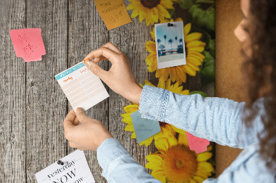 Memobord van kurk met zonnebloemen op een houten achtergrond