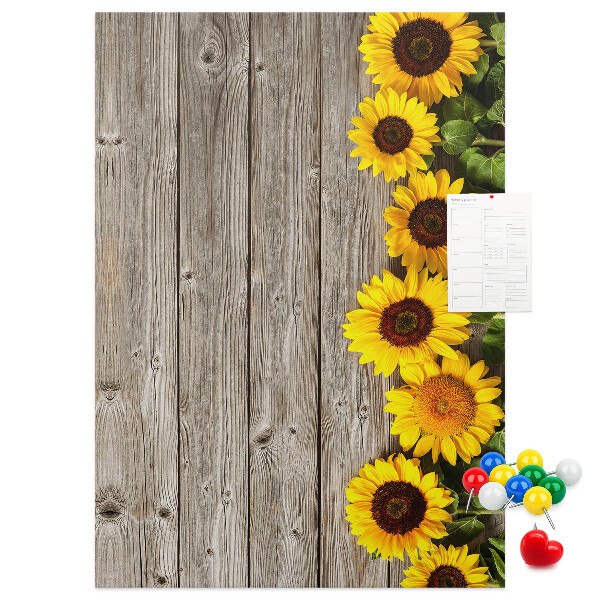 Memobord van kurk met zonnebloemen op een houten achtergrond