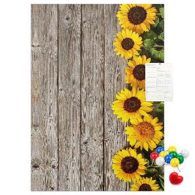 Memobord van kurk met zonnebloemen op een houten achtergrond