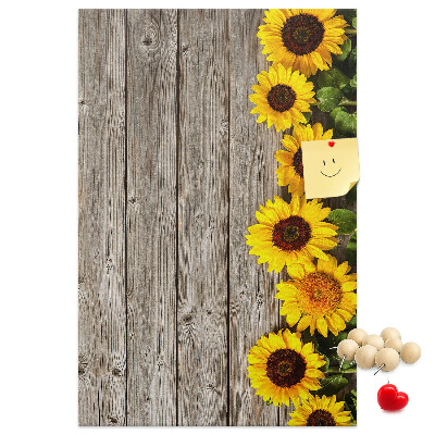 Memobord van kurk met zonnebloemen op een houten achtergrond