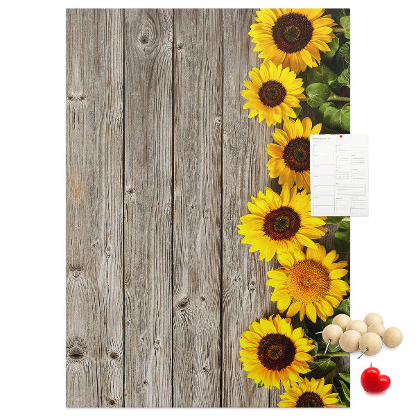 Memobord van kurk met zonnebloemen op een houten achtergrond