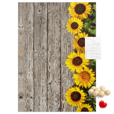 Memobord van kurk met zonnebloemen op een houten achtergrond