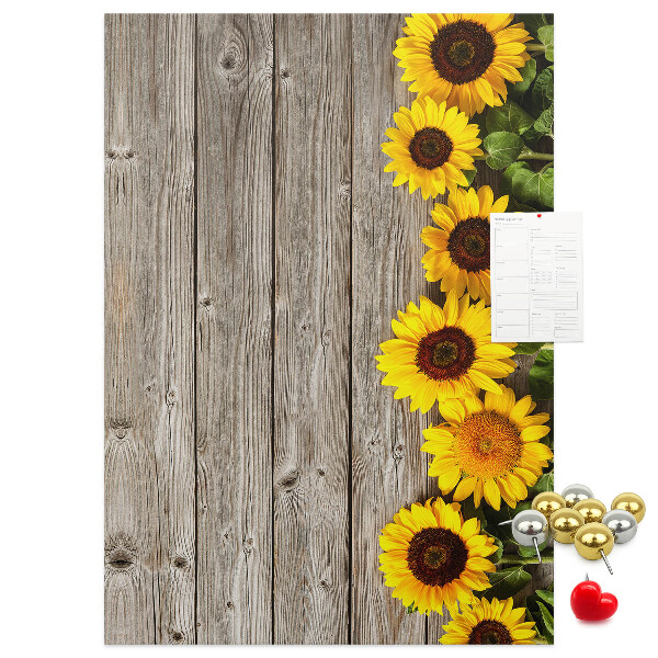 Memobord van kurk met zonnebloemen op een houten achtergrond