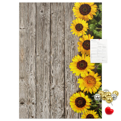Memobord van kurk met zonnebloemen op een houten achtergrond