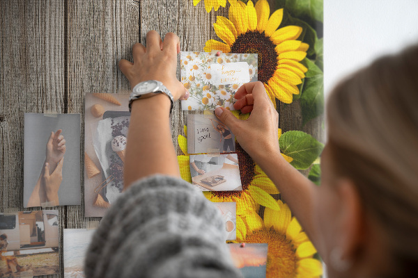 Memobord van kurk met zonnebloemen op een houten achtergrond
