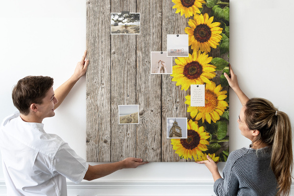 Memobord van kurk met zonnebloemen op een houten achtergrond