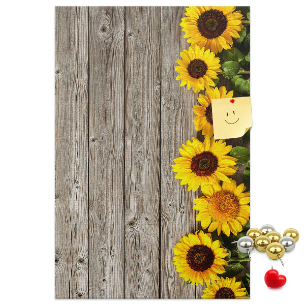 Memobord van kurk met zonnebloemen op een houten achtergrond